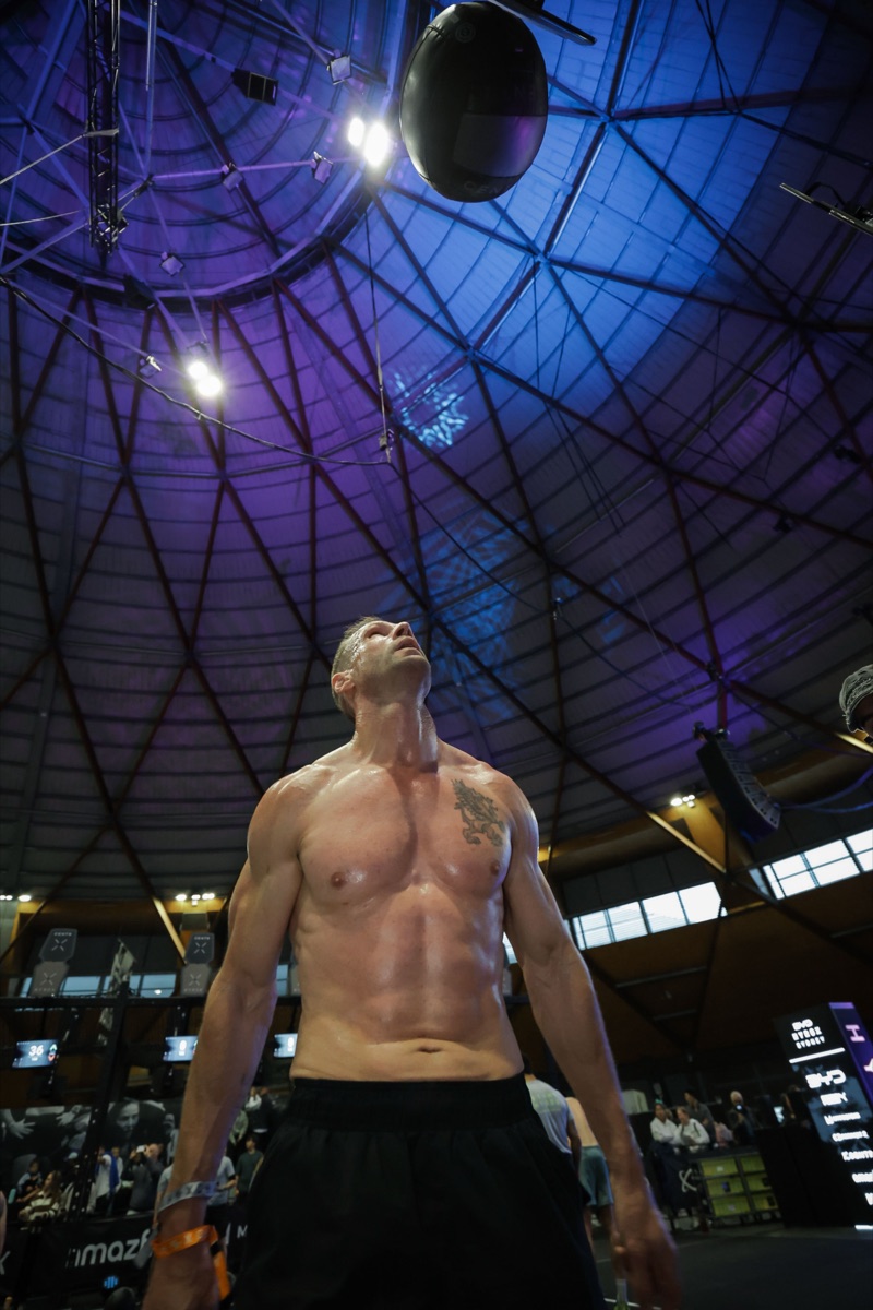 Tyson Schubert looking upward beneath a wall ball during HYROX Sydney