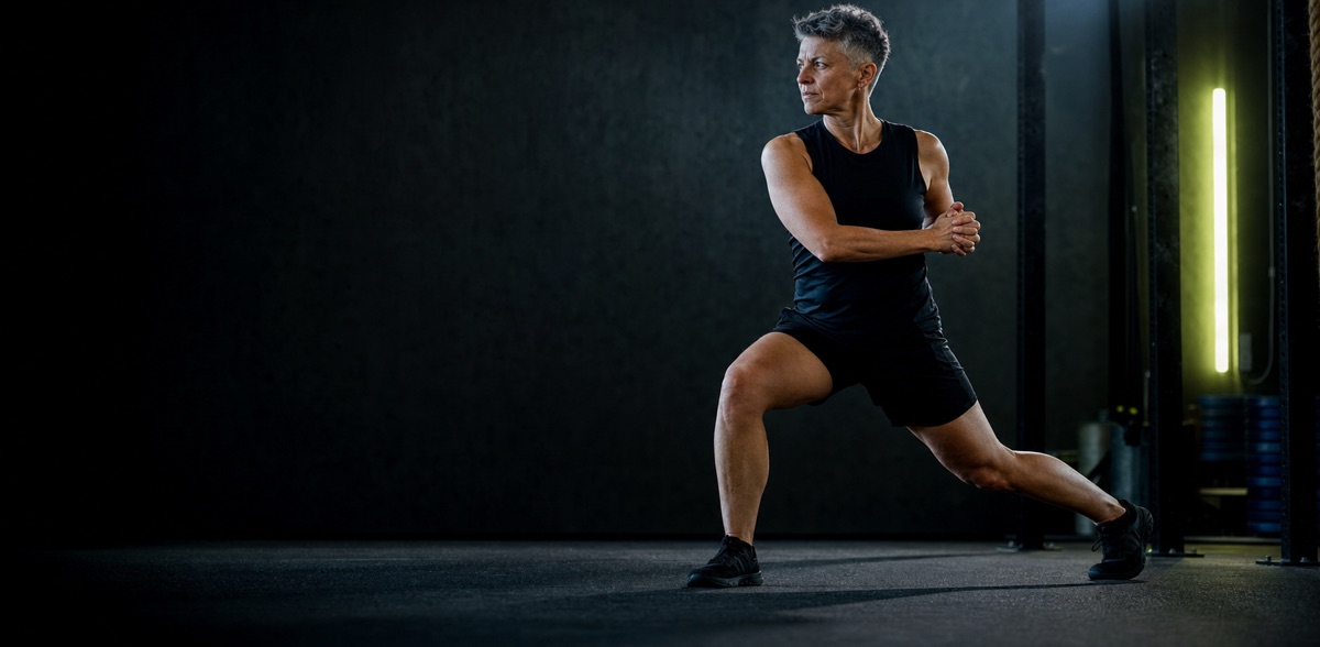 Mature athlete performing a controlled split-stance warm-up